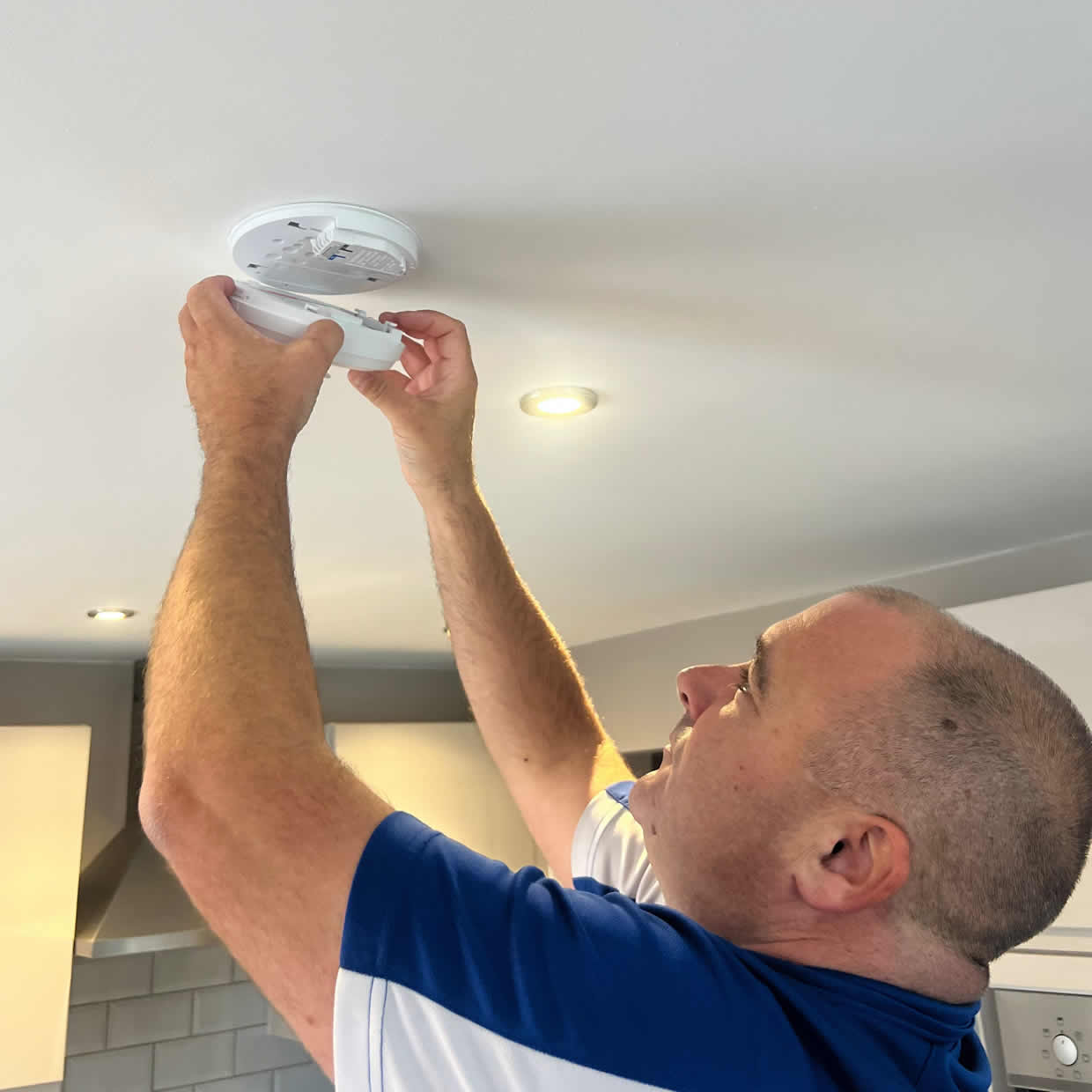 Smoke alarm installer fitting an alarm in a Sale property